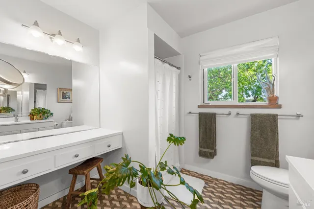 a bathroom with a sink a toilet and a mirror