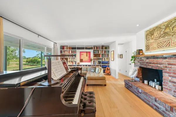a living room with furniture a fireplace and a large window