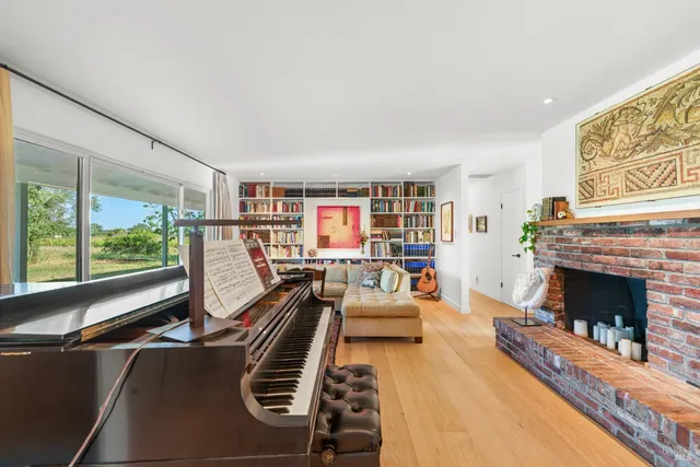 a living room with furniture a fireplace and a large window