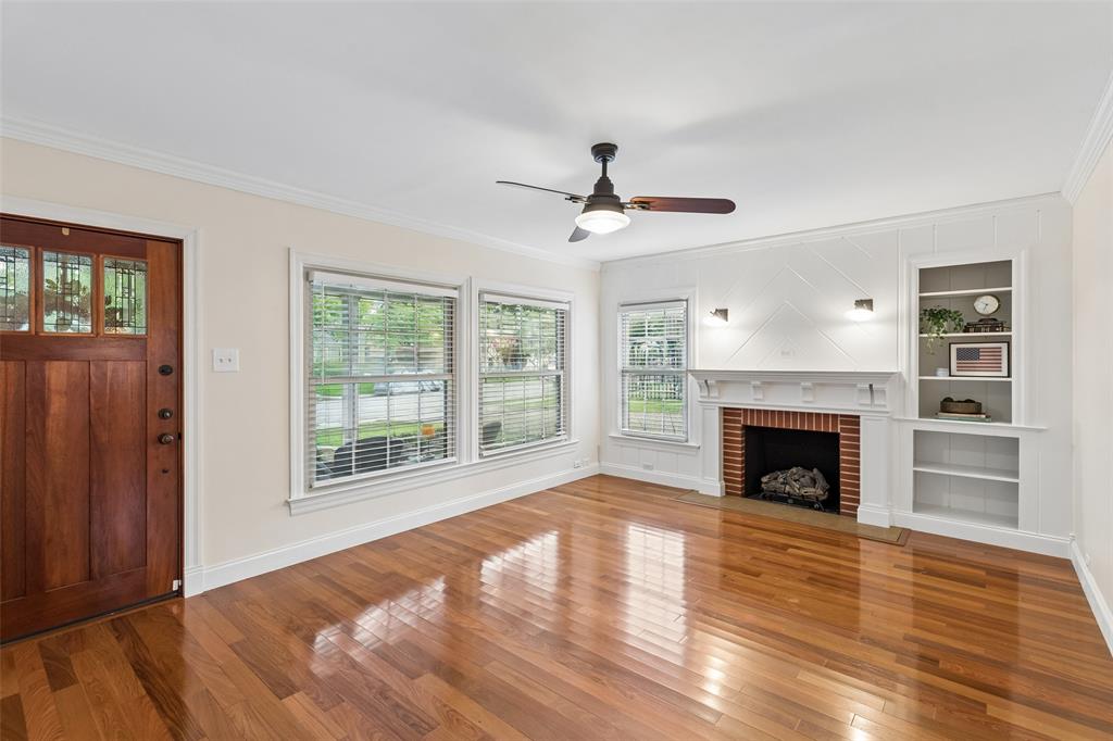 2427 Alco Avenue Dallas, TX 75211 - Photo 10 of 26 a view of an empty room with wooden floor fireplace and a window