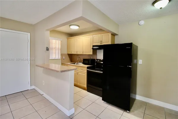a kitchen with a refrigerator a sink and cabinets
