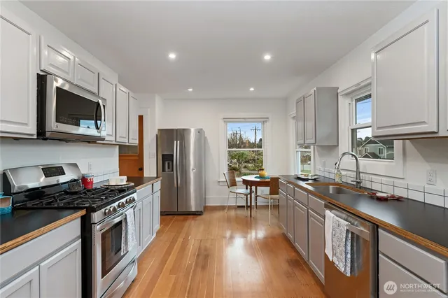 a kitchen with stainless steel appliances a stove sink microwave and cabinets