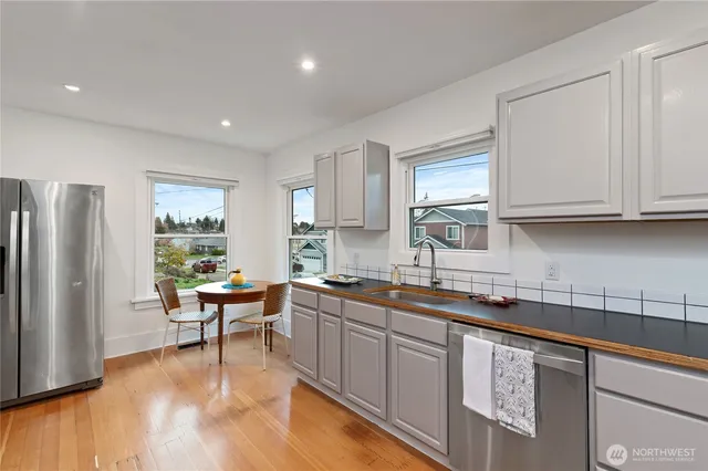 a kitchen with stainless steel appliances granite countertop a sink stove and refrigerator