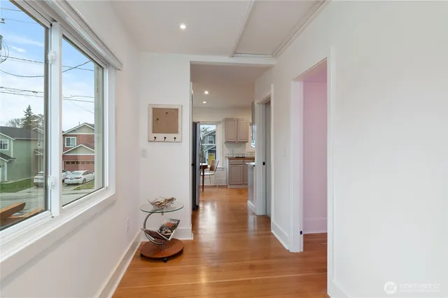 a hallway with wooden floor and a bathroom
