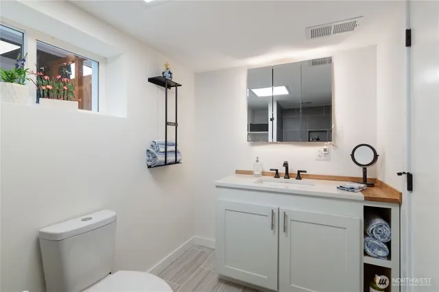 a bathroom with a toilet sink and mirror