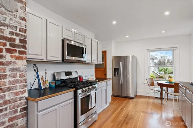 a kitchen with stainless steel appliances granite countertop a stove a sink and a refrigerator