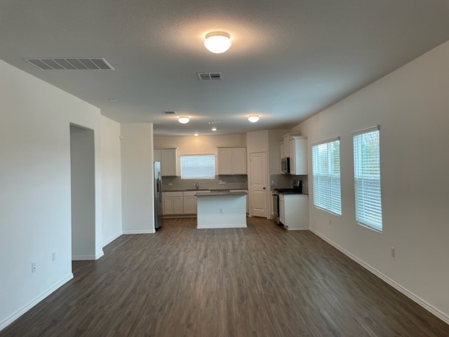 10413 Premier Park Street Austin, TX 78747 - Photo 7 of 24 a large open kitchen with a white countertops a stove a dining table and chairs