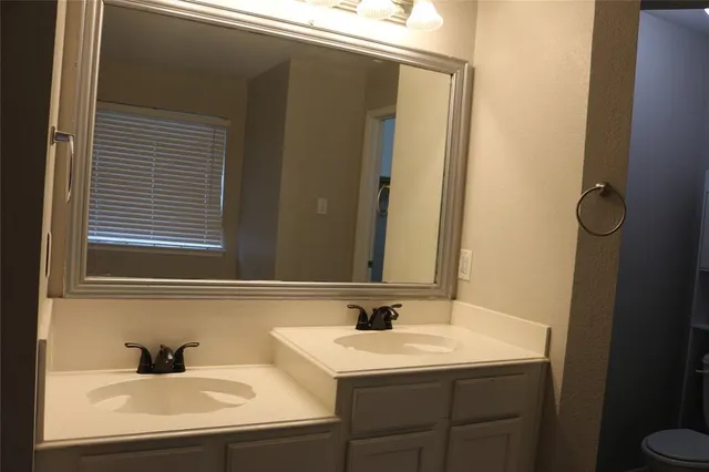 a kitchen with stainless steel appliances granite countertop a sink a stove a refrigerator a microwave oven with white cabinets and wooden floor