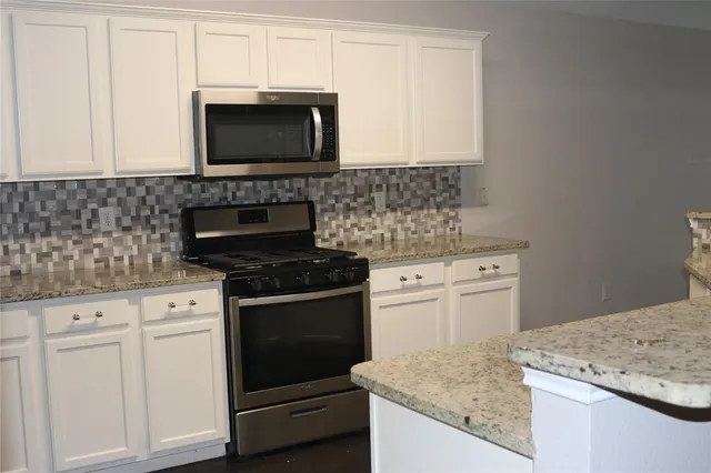 a bathroom with a granite countertop sink and a window