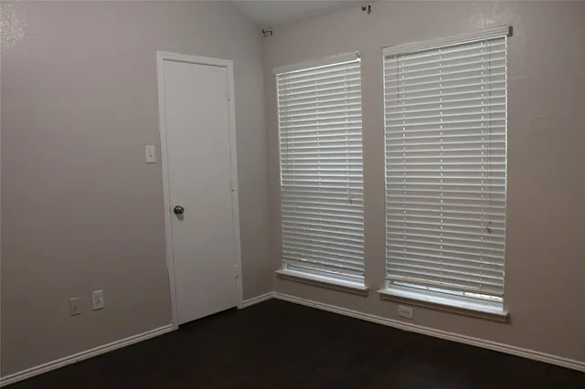 a view of a small space with wooden floor and a window