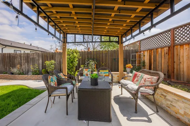 a view of a patio with a dining table and chairs with wooden floor