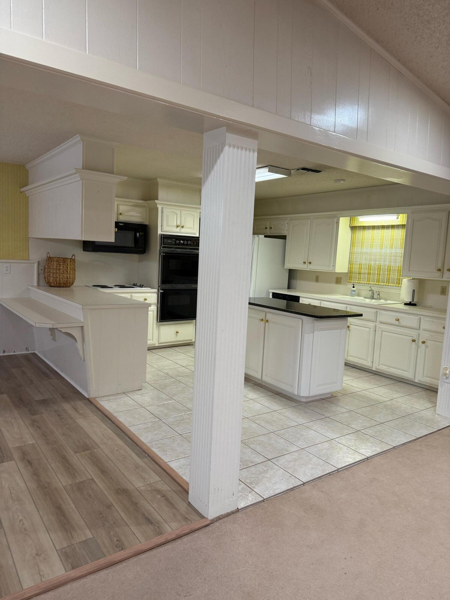 3012 69th Street Lubbock, TX 79413 - Photo 14 of 38 a large white kitchen with stainless steel appliances granite countertop a stove and a sink