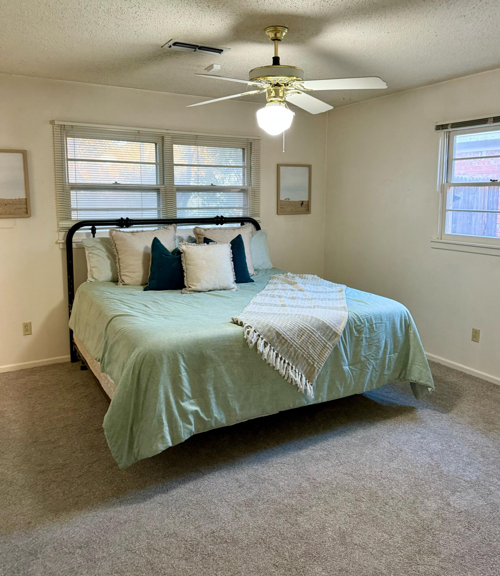3012 69th Street Lubbock, TX 79413 - Photo 18 of 38 a bedroom with a large bed and a chandelier