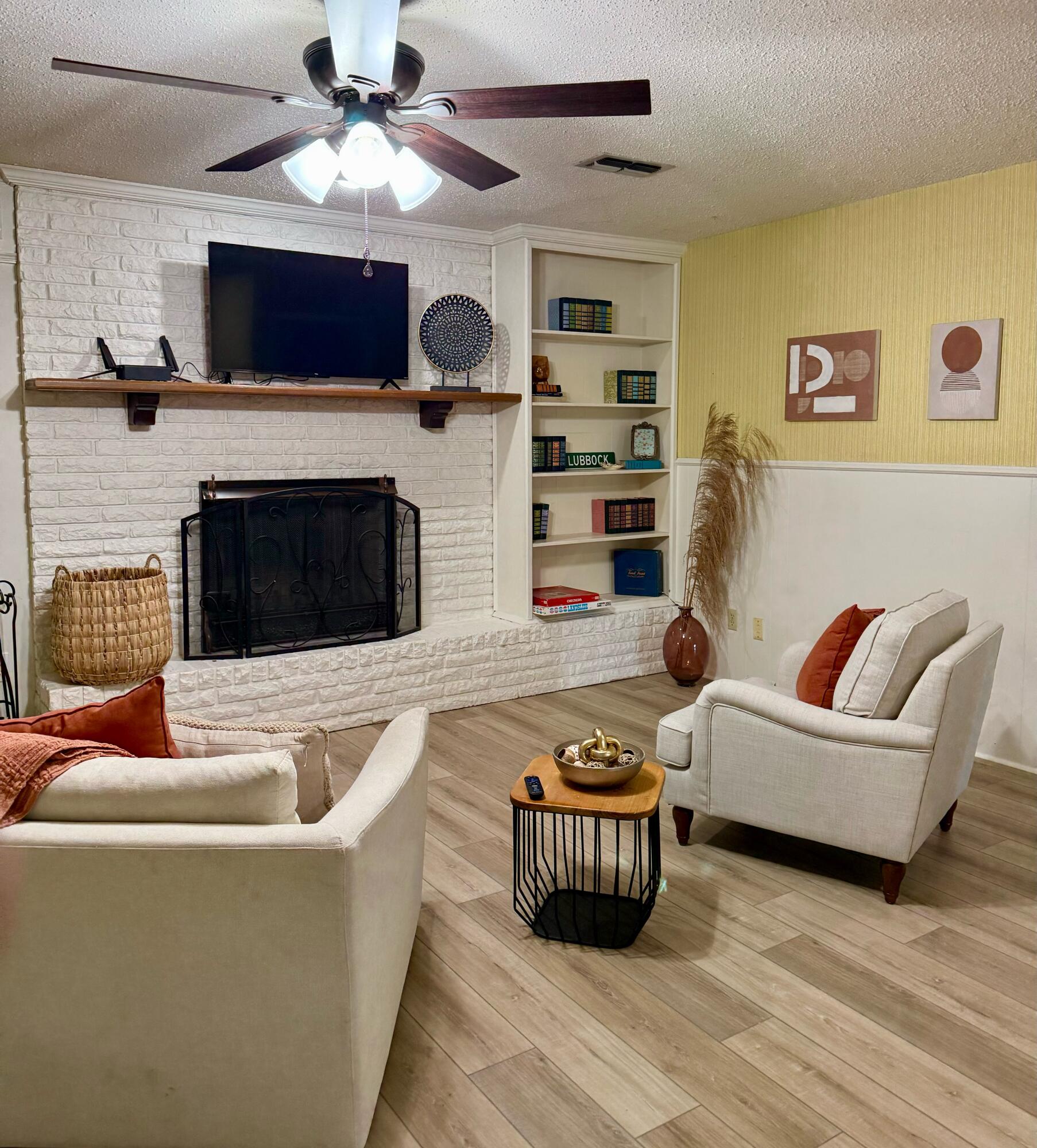 3012 69th Street Lubbock, TX 79413 - Photo 5 of 38 a living room with furniture a flat screen tv and a fireplace