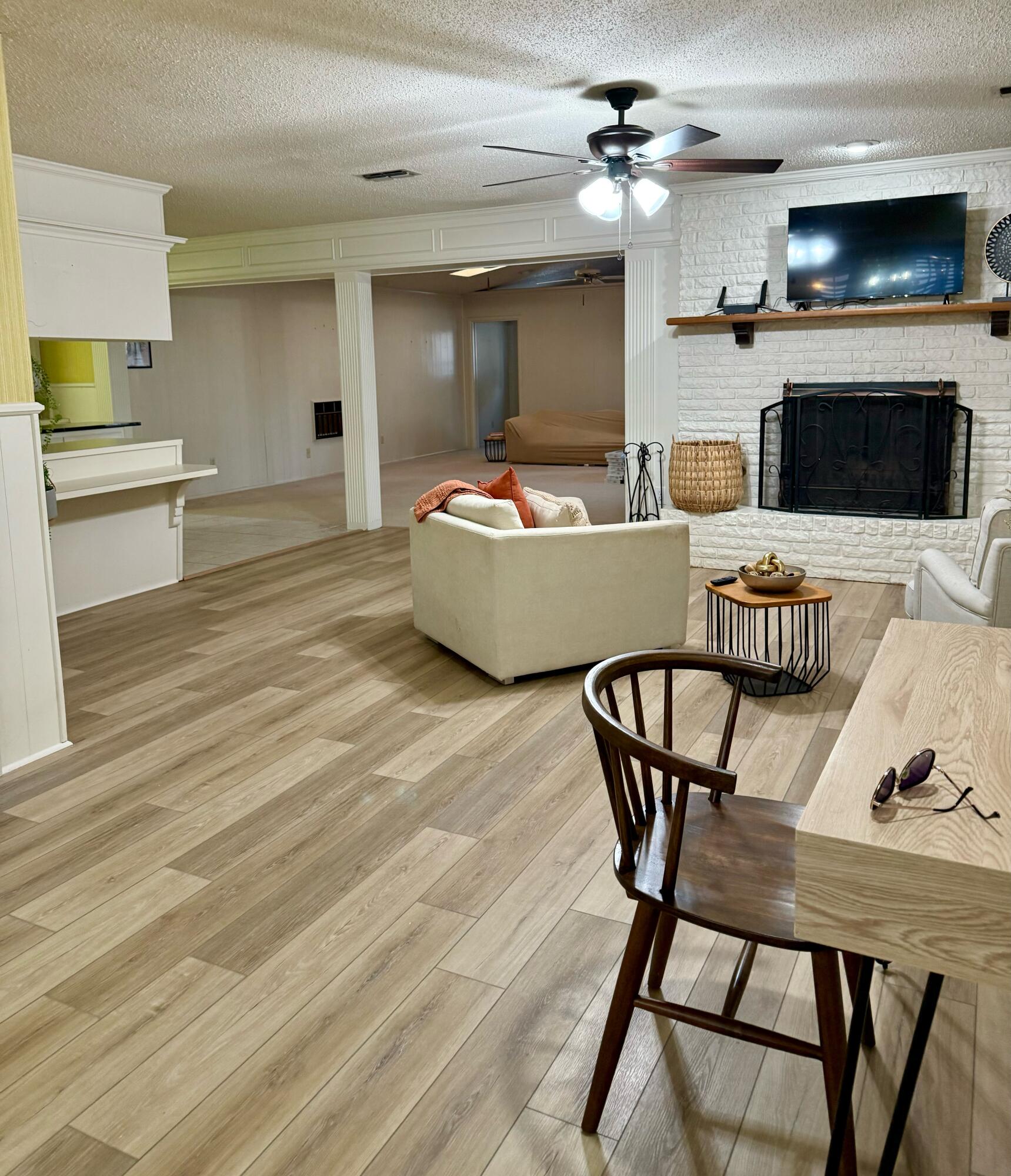3012 69th Street Lubbock, TX 79413 - Photo 7 of 38 a living room with furniture a fireplace and a flat screen tv