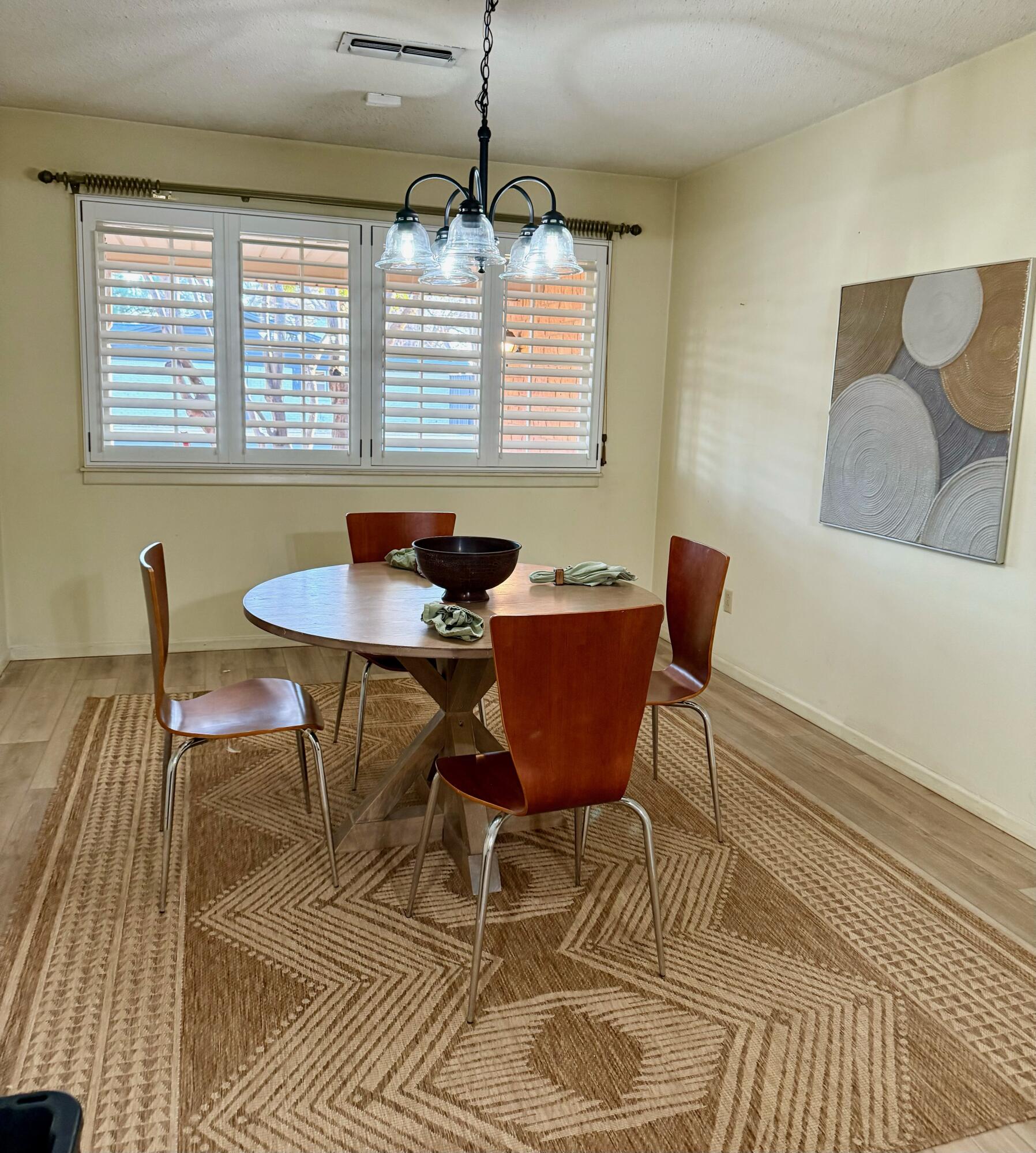 3012 69th Street Lubbock, TX 79413 - Photo 9 of 38 a dining room with furniture a chandelier and wooden floor