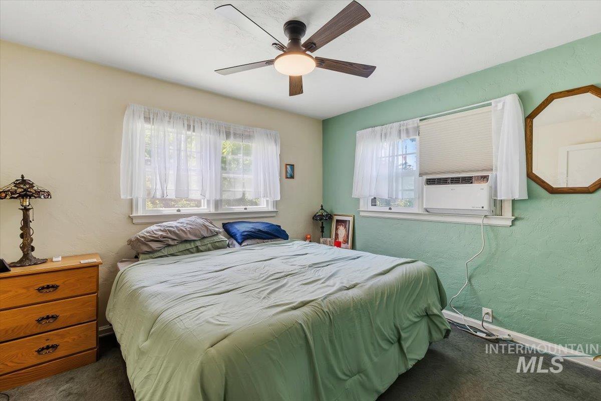4619 Freemont Street Boise, ID 83706 - Photo 10 of 27 Bedroom featuring a ceiling fan with integrated lighting, multiple windows, window-mounted air conditioning unit, and textured wall finish