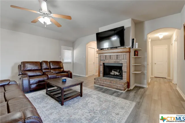 a living room with furniture a flat screen tv and a fireplace
