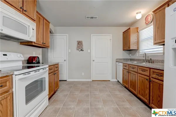 a kitchen with stainless steel appliances granite countertop a washer and dryer