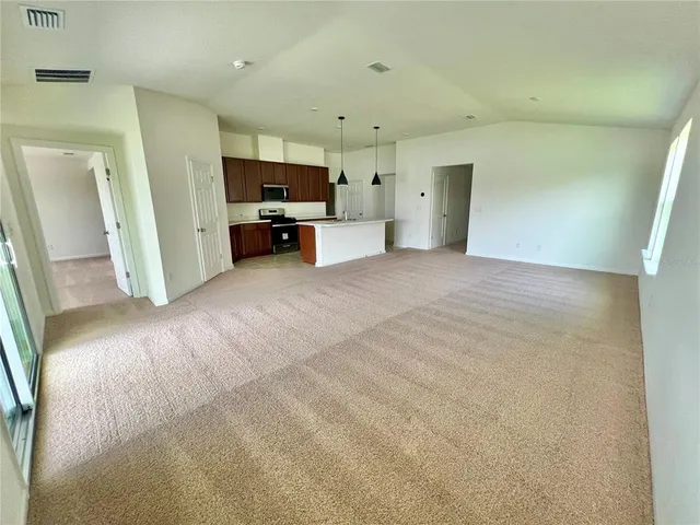 a view of empty room with a kitchen
