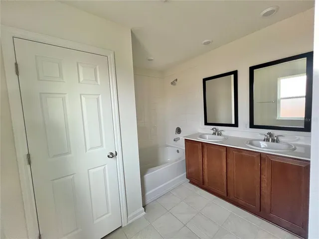 a bathroom with double vanity and a mirror