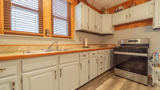 a kitchen with stainless steel appliances white cabinets and a sink