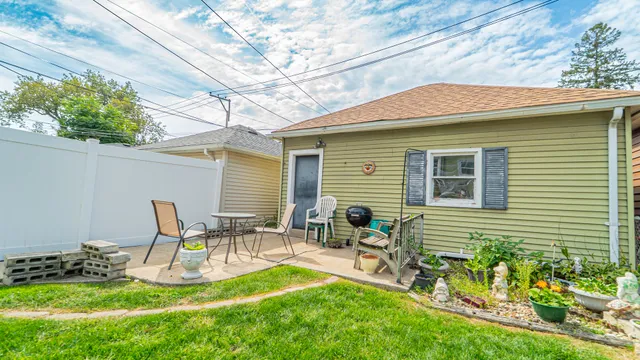 a view of backyard with table and chairs and potted plants