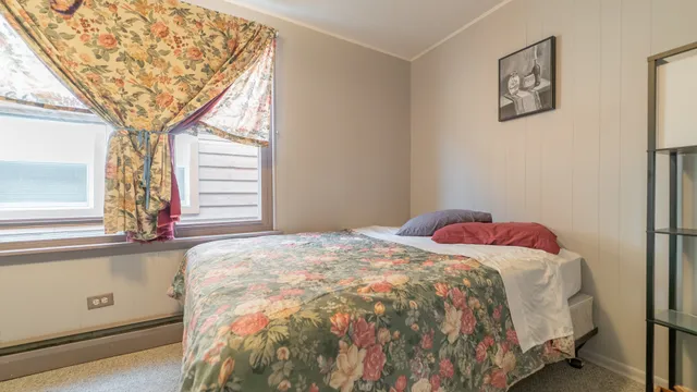 a bedroom with a bed and a large window