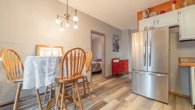 a kitchen with stainless steel appliances granite countertop a refrigerator a stove a microwave oven with a dining table and chairs