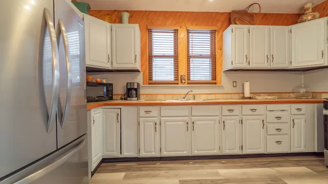 a kitchen with stainless steel appliances granite countertop a sink a refrigerator and cabinets