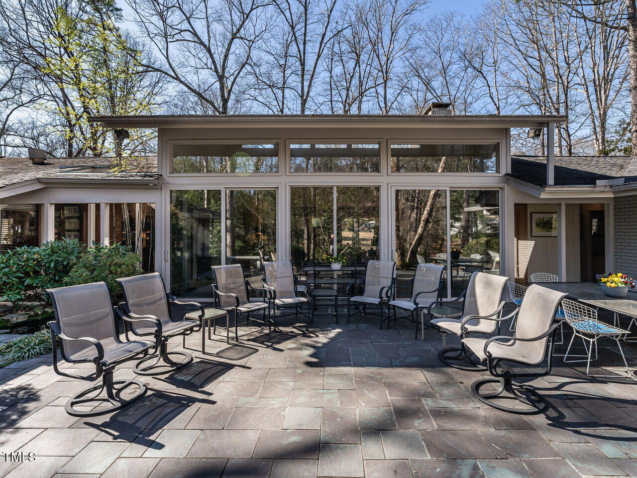 3206 Sussex Road Raleigh, NC 27612 - Photo 43 of 51 a view of a patio with table and chairs and floor to ceiling window and wooden fence