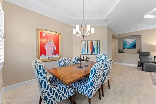 a view of a dining room with furniture a chandelier and wooden floor