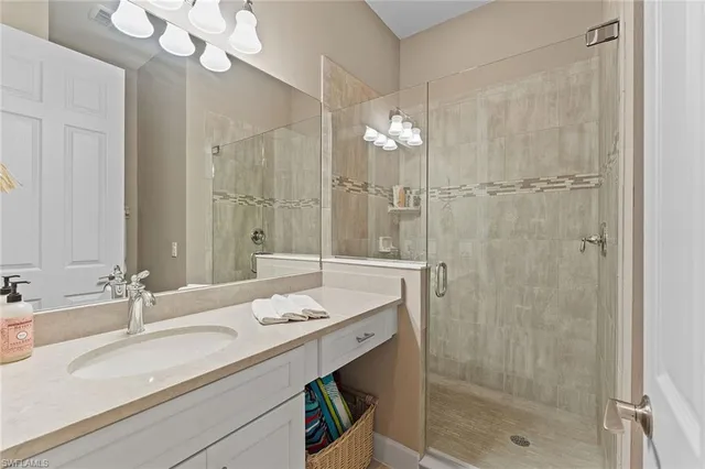 a bathroom with a double vanity sink mirror and shower