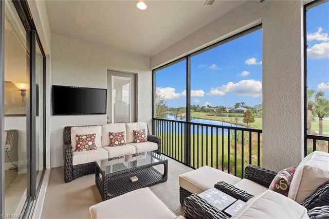 a living room with furniture floor to ceiling window and a flat screen tv