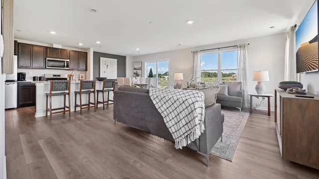 a living room with furniture a flat screen tv and wooden floor