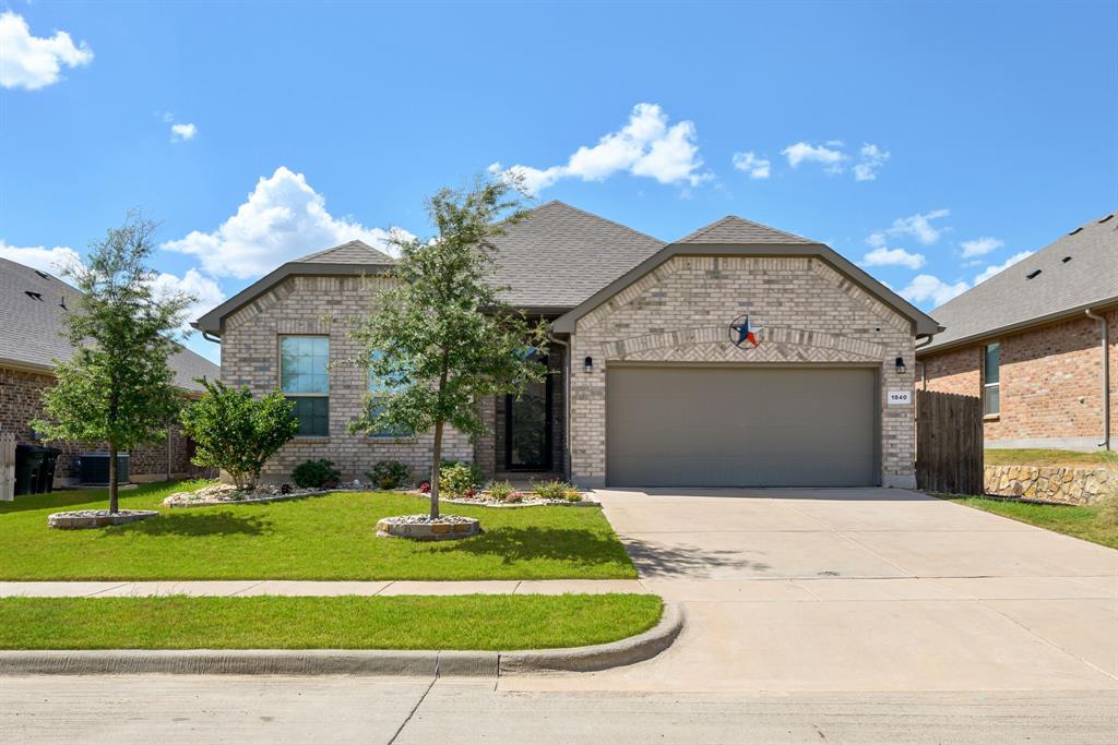 1840 Ruffian Road Granbury, TX 76049 - Photo 1 of 33 Brick exterior, attached garage, concrete driveway, front yard landscaping, and mature trees