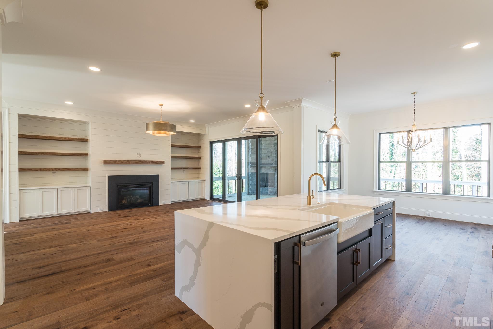 3820 Noremac Drive Raleigh, NC 27612 - Photo 18 of 46 a kitchen with a stove kitchen island and a wooden floor