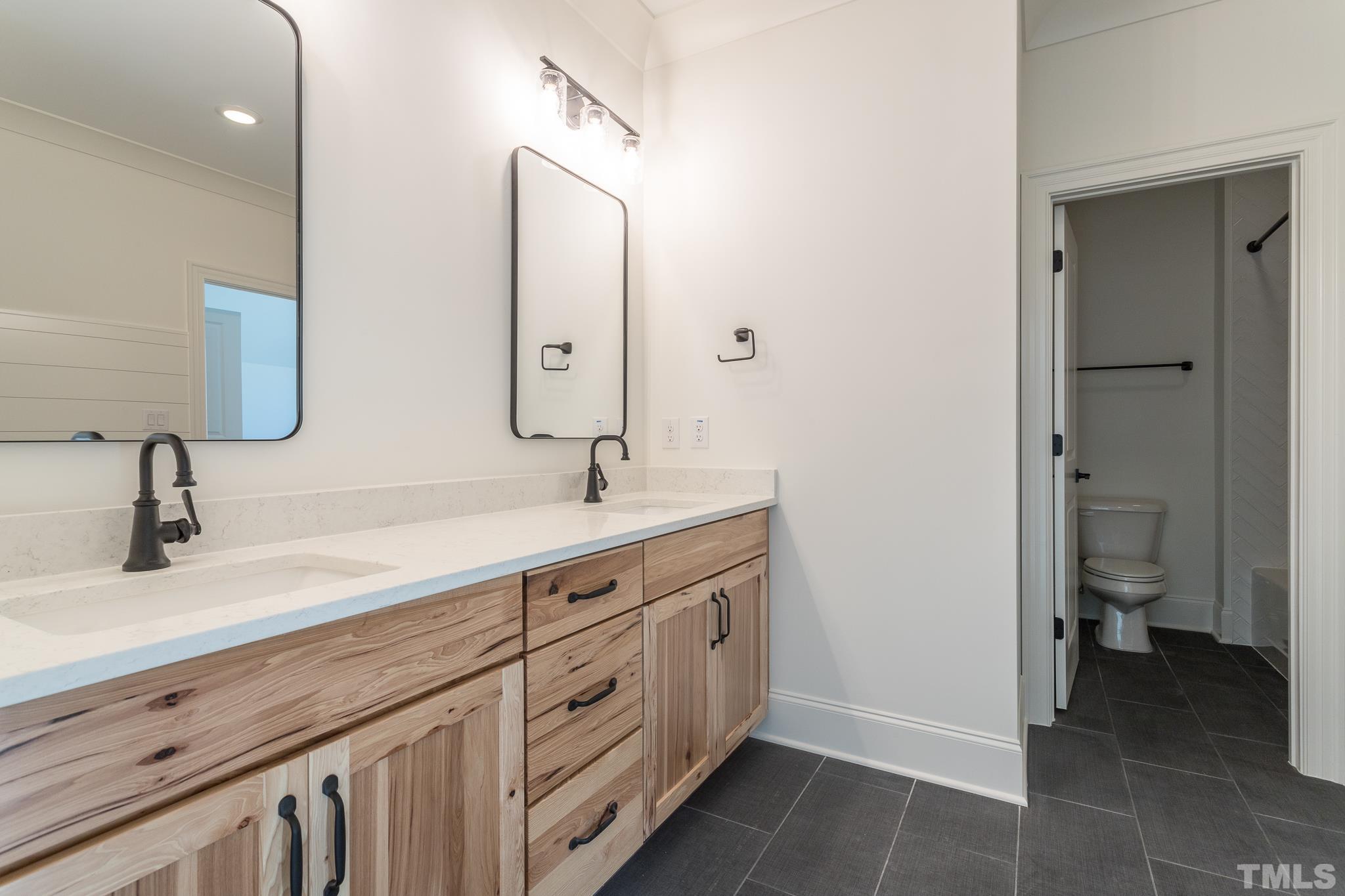 3820 Noremac Drive Raleigh, NC 27612 - Photo 37 of 46 a spacious bathroom with a double vanity sink a mirror and a toilet