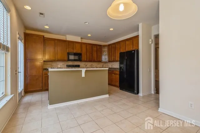 a kitchen with kitchen island granite countertop cabinets and refrigerator