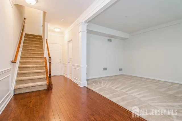 a view of a room with wooden floor and white walls