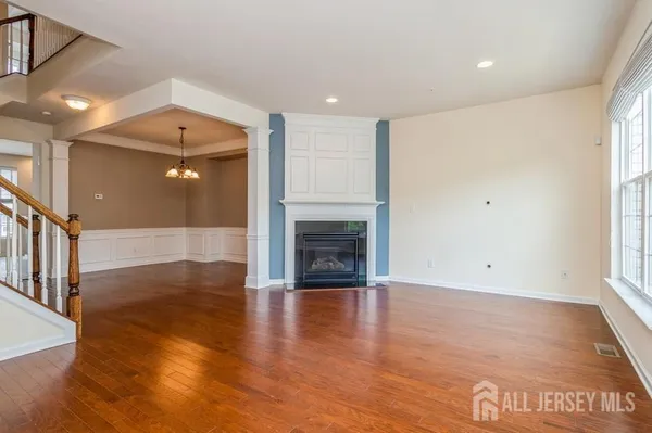 a view of a livingroom with wooden floor and a fireplace