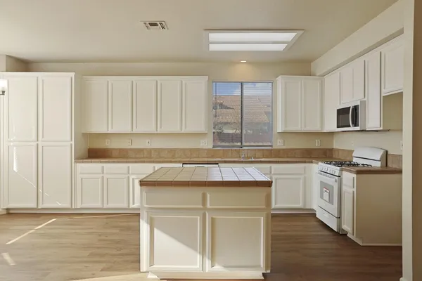 a kitchen with stainless steel appliances granite countertop a sink stove and microwave
