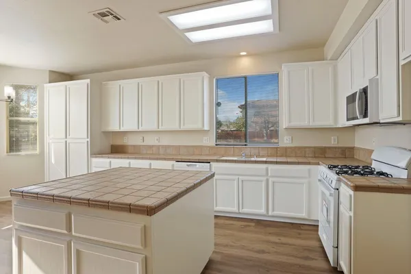 a kitchen with granite countertop a sink stove and cabinets