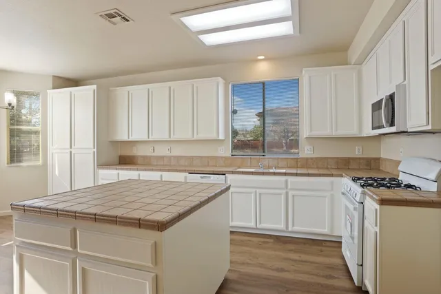 a kitchen with granite countertop a sink stove and cabinets