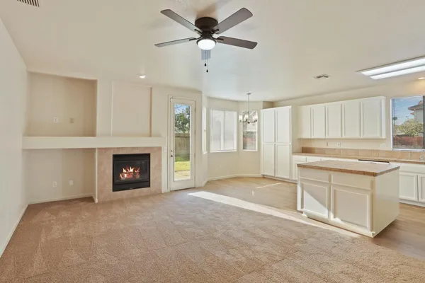 a kitchen with stainless steel appliances granite countertop a refrigerator a sink dishwasher a stove and white cabinets with wooden floor
