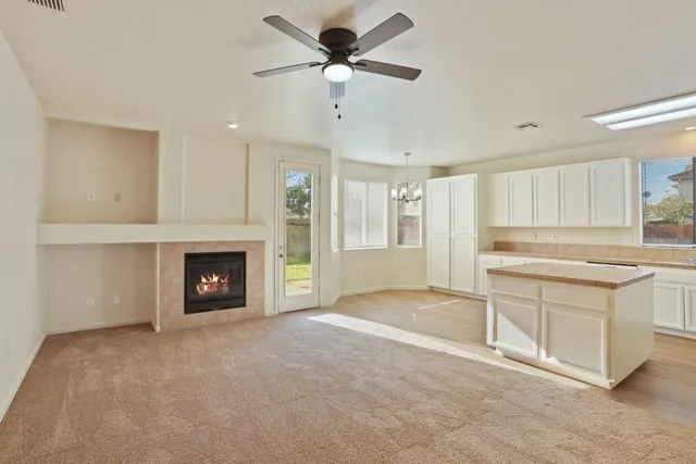 a kitchen with stainless steel appliances granite countertop a refrigerator a sink dishwasher a stove and white cabinets with wooden floor