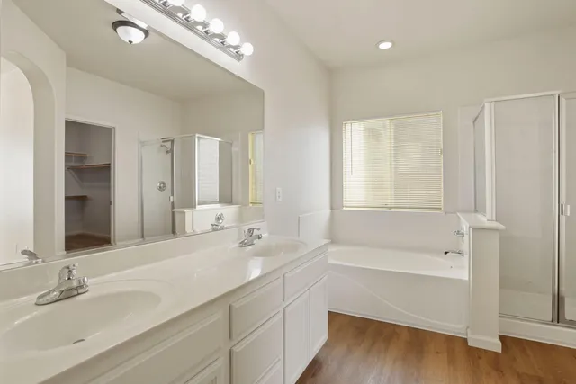 an empty room with windows and chandelier fan