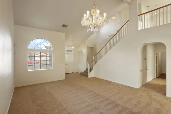 a view of an empty room with window and fireplace