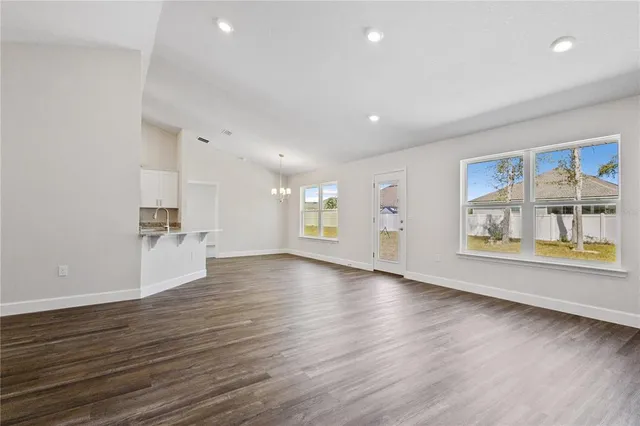 an empty room with wooden floor and window