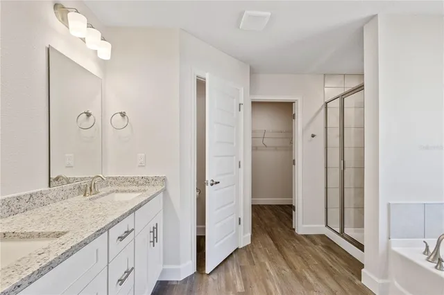 a bathroom with a granite countertop sink a mirror and a shower